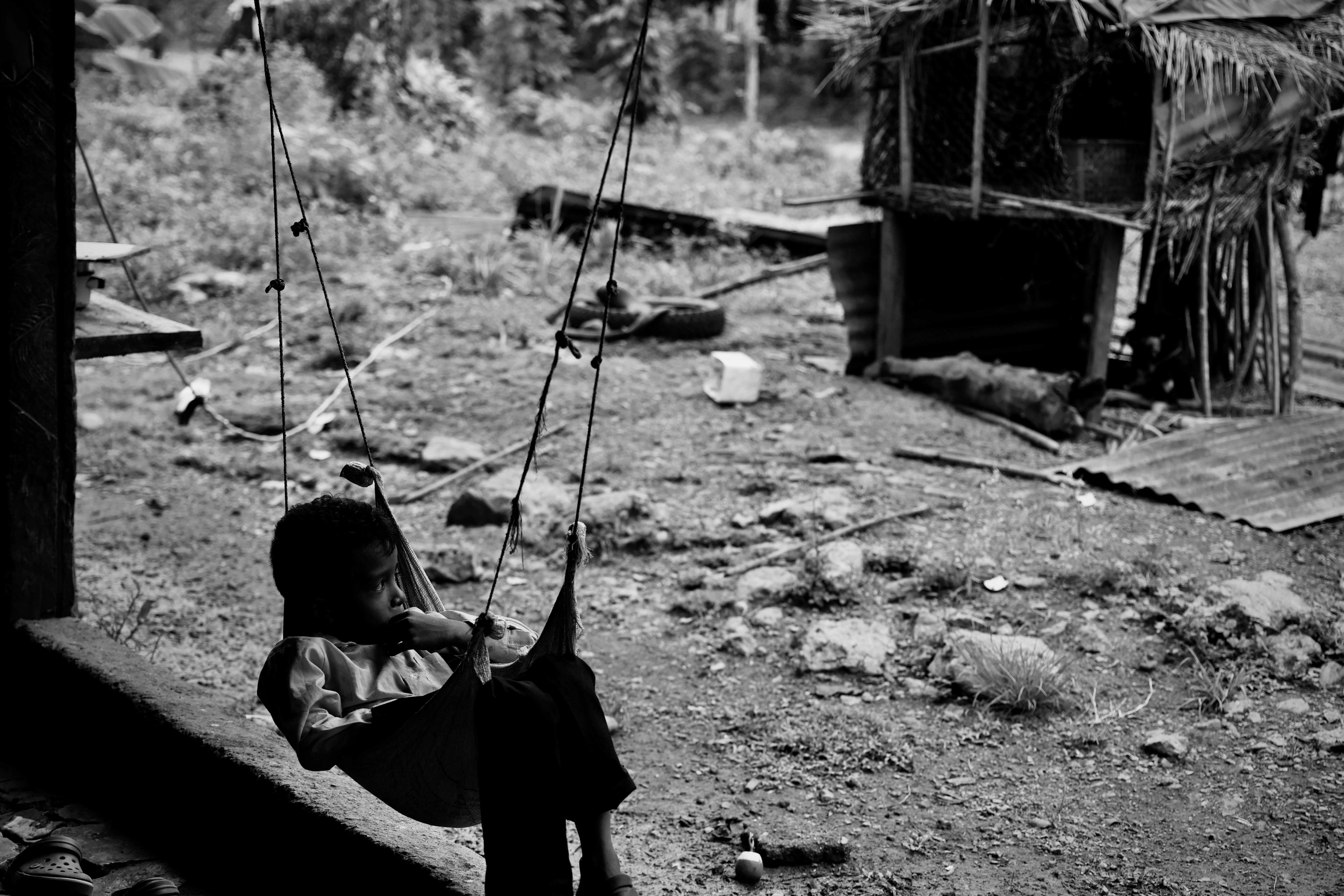 A child on a rope swing — black and white