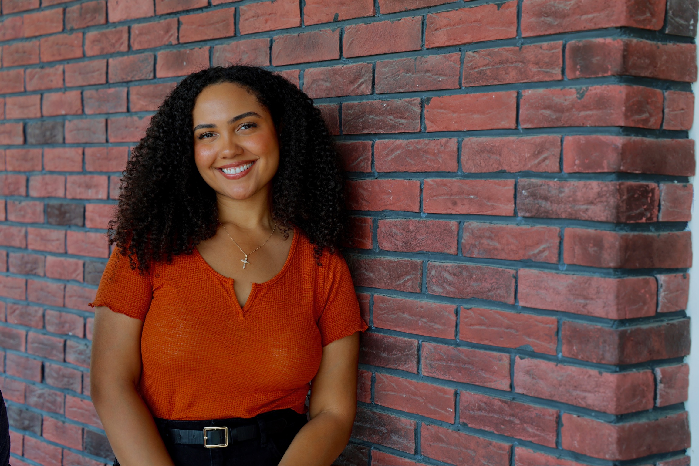 Woman smiling by brick wall